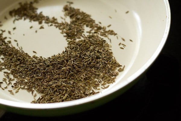 roasting caraway seeds to make amti masala.