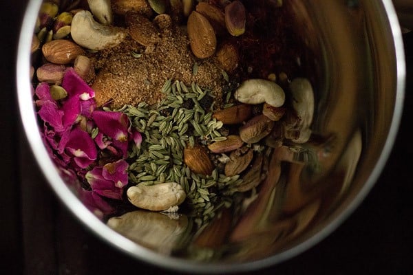 roasted dry fruits, seeds, grated nutmeg, dried rose petals, fennel seeds, turmeric powder, black peppercorns, cardamom seeds and sugar added to a dry grinder jar. 