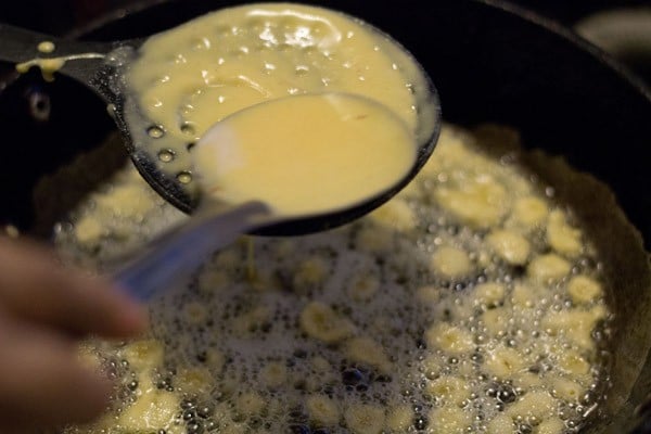 besan batter on a perforated ladle