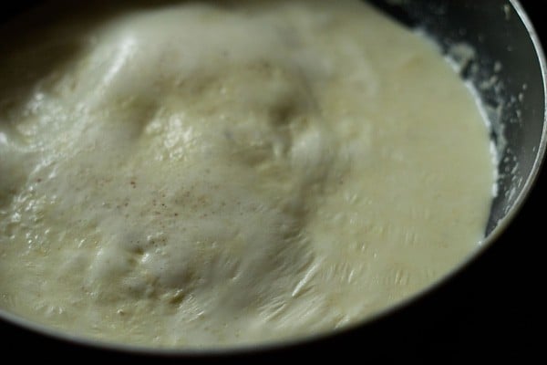 milk is thickening and simmering, with milk solids beginning to separate