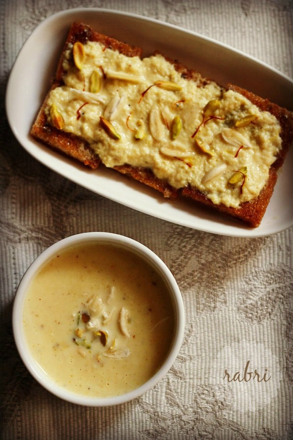 bowl of rabri next to plate of shahi tukda on a beige patterened tablecloth