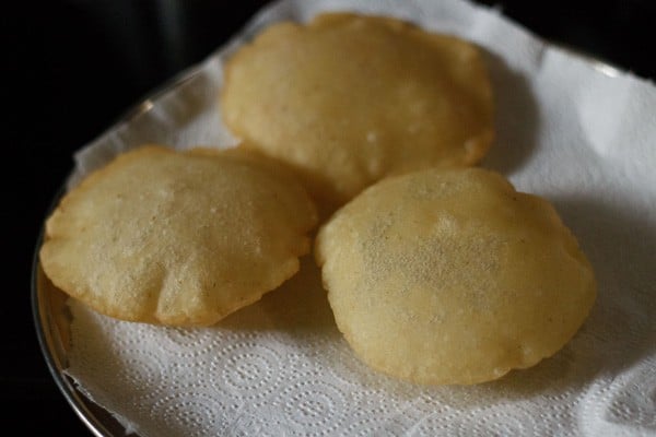 draining fried rice puris on paper towels. 