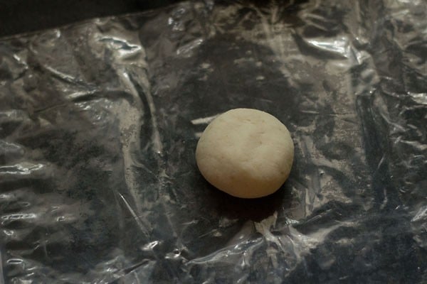 dough ball kept on a plastic sheet. 