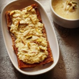 shahi tukda in a white oblong serving plate with a bowl of homemade rabri