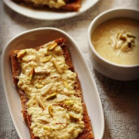 shahi tukda in a white oblong serving plate with a bowl of homemade rabri