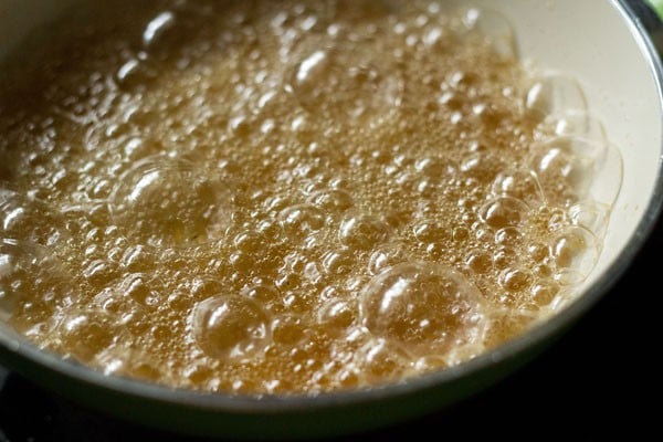 sugar syrup at a rapid boil with large and small bubbles covering the surface