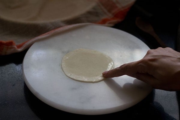 applying water at the edges of the rolled dough with finger tips. 
