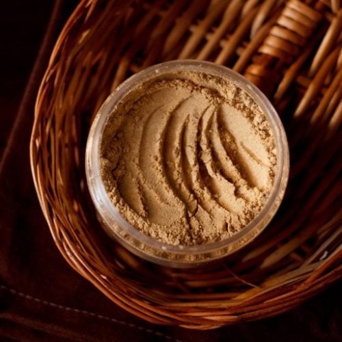 amchur powder in a jar on oval bamboo tray.