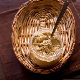 amchur powder in a jar with spoon inside