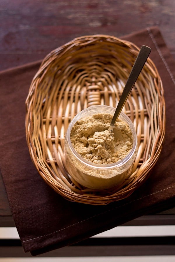 amchur powder in a jar with spoon inside