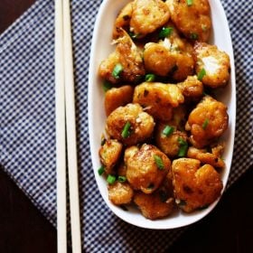 top shot of dry gobi manchurian served a white plate with chopsticks