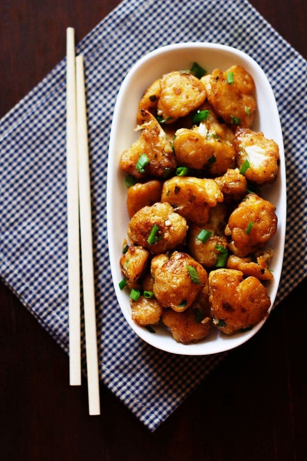 top shot of dry gobi manchurian served a white plate with chopsticks