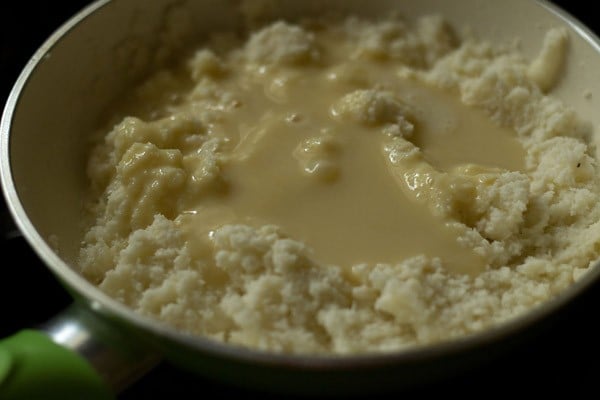 adding condensed milk to the coconut mixture in pan.