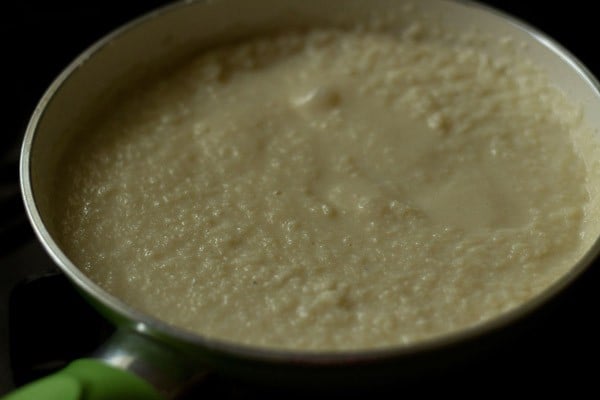 cooking coconut burfi mixture in pan.