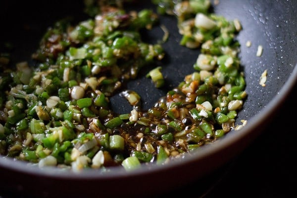 ginger, garlic, spring onions, green capsicum and green chilies and seasoning in a pan