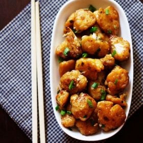 top shot of dry gobi manchurian served a white plate with chopsticks