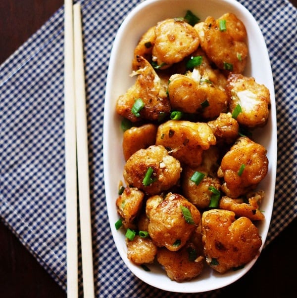 top shot of dry gobi manchurian served a white plate with chopsticks
