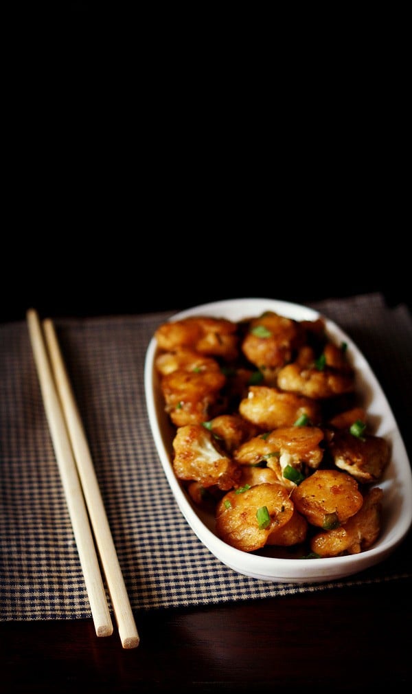 dry gobi manchurian served a white plate with chopsticks