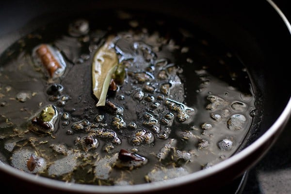 crackling whole spices in hot oil in a pan. 