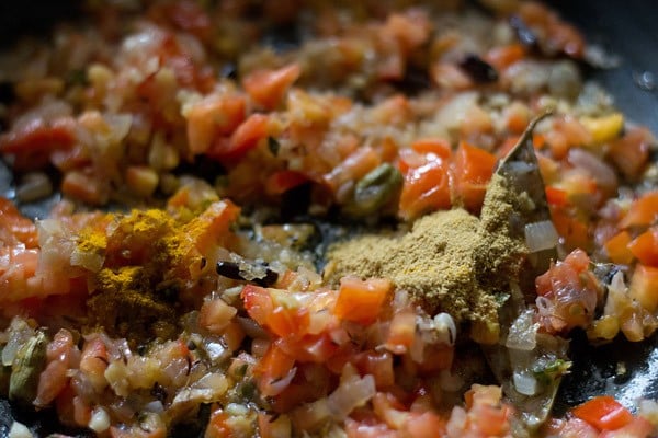 spice powders added ro onion-tomato mixture in pan. 