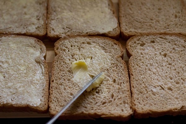 spreading butter evenly on all the slices