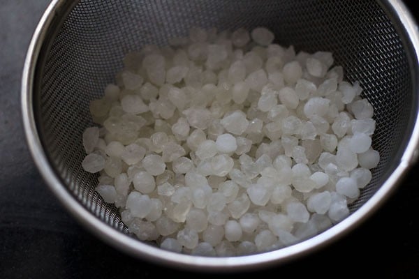 Place nylon sabudana pearls in a metal fry strainer for sabudana namkeen. 