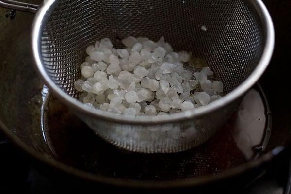 frying nylon sabudana pearls for making sabudana namkeen. 