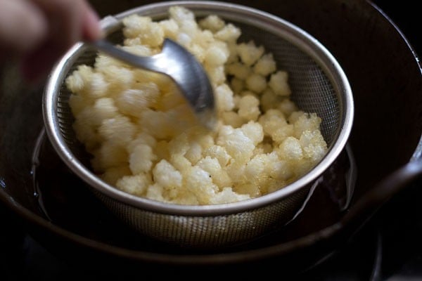 frying nylon sabudana pearls for making sabudana namkeen. 