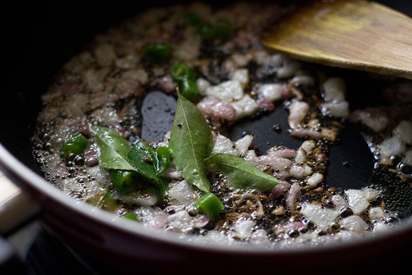 stirring curry leaves and chopped green chili in the spice mixture. 