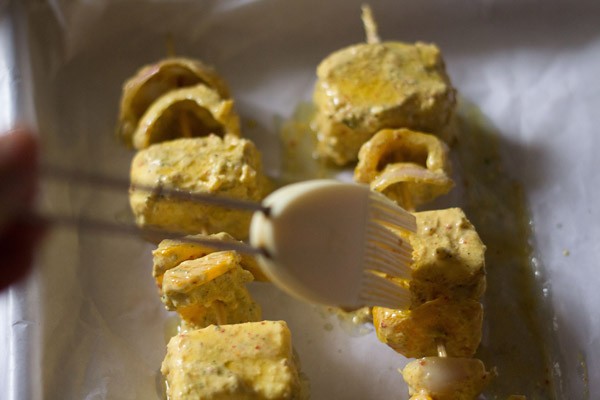 brush oil on marinated paneer cubes