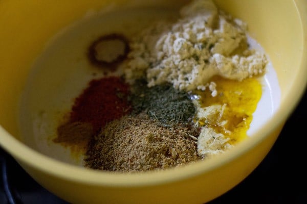 adding various spices to whisked curd 