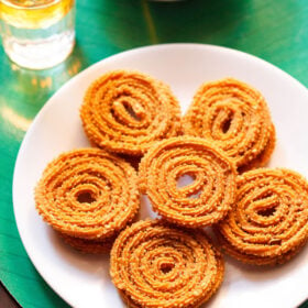 chakli in round shape with a chakli in the center on a white plate on a green background