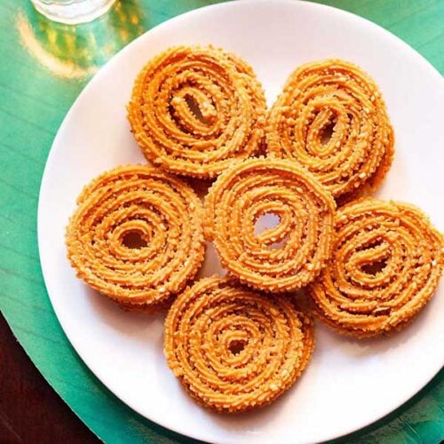 chakli kept on a white plate on a green background