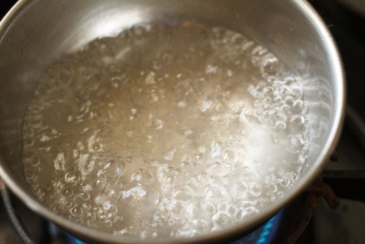 boiling water in a steel bowl on a stove-top