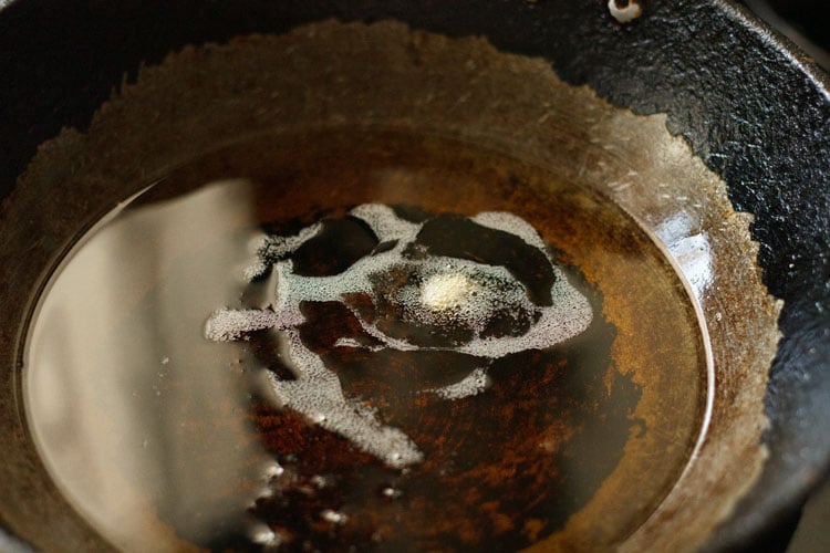 checking a small piece of dough in the hot oil for frying