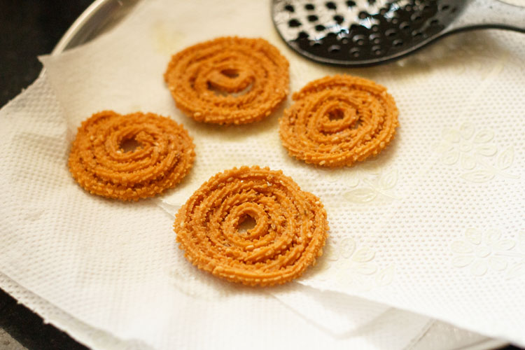 four fried chakli kept on kitchen paper towels