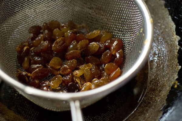 raisins added to fine sieve ladle for making cornflakes chivda. 