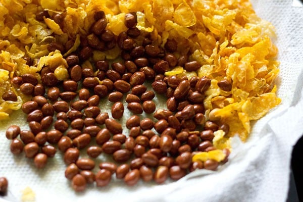 Fried peanuts and tortilla chips are served on a kitchen towel. 