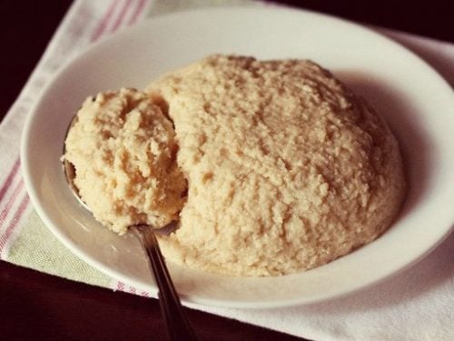 homemade khoya mawa served on a white plate with some in the spoon kept on the left side.