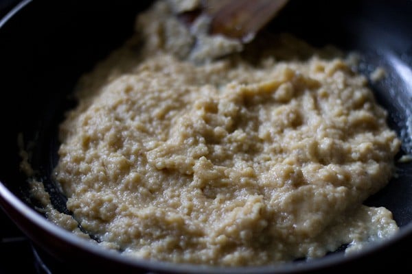 stirring the sugar in the khoya for khoya burfi. 