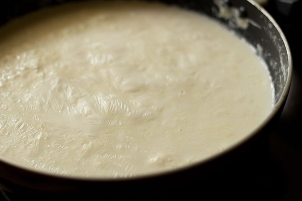 simmering milk for making mawa or khoya recipe is starting to get a skin over the top.