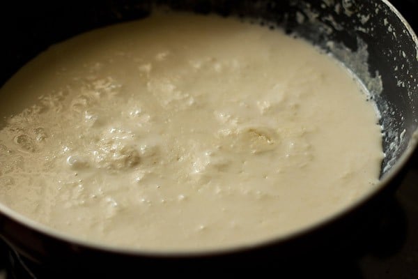 preparing khoya or mawa recipe — the milk looks thick and curdled at this point.
