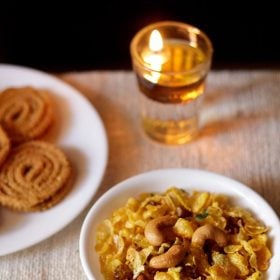 cornflakes chivda served in a white plate with a plate of murukku kept on the left side.