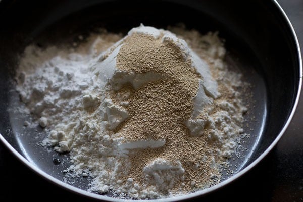 all purpose flour, instant yeast and sugar added in a bowl for making ladi pav. 