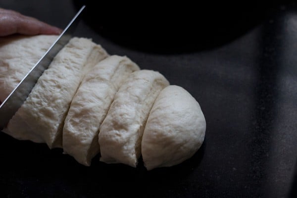 slicing dough log into equal portions.