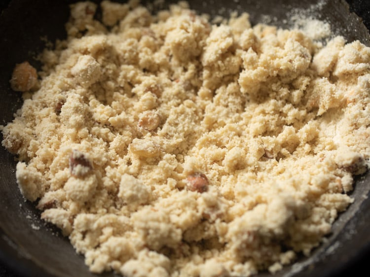 rava laddu mixture mixed well with the fried nuts and hot ghee. 