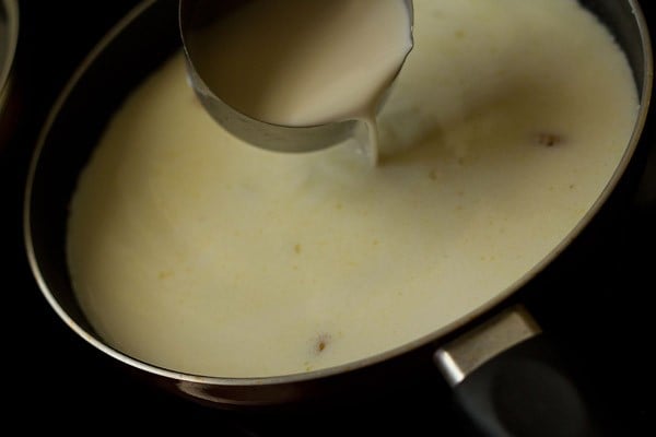 adding milk to rava mixture in pan.