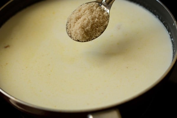 adding sugar to sooji mixture in the pan