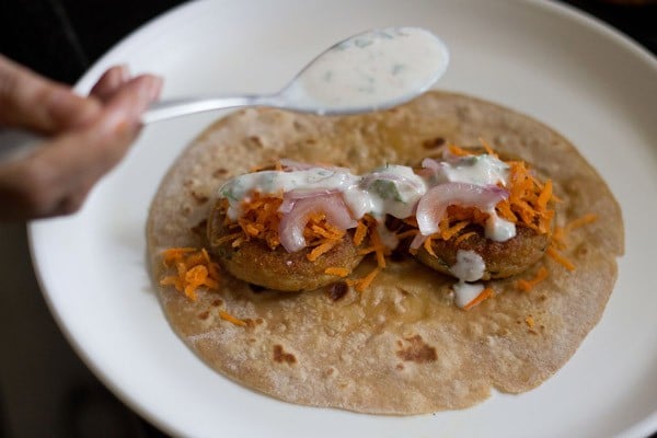 roti, tikkis, grated carrots, sliced onions and sweet yogurt