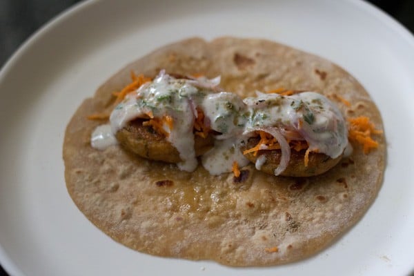 roti, tikkis, grated carrots, sliced onions, sweet yogurt and chaat masala